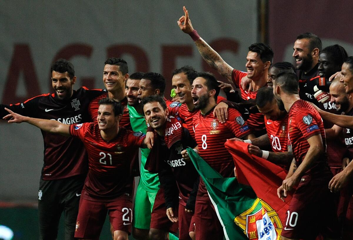 Portugal players celebrate at the end of the Euro 2016 qualifying group I soccer match between Portugal and Denmark at the Municipal Stadium in Braga, Portugal, Thursday, Oct. 8 2015. Portugal defeated Denmark 1-0. (AP Photo/Paulo Duarte)