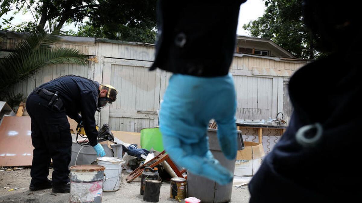 Especialistas en materiales peligrosos revisan artículos en un callejón de Los Ángeles que recientemente había sido limpiado de 16 toneladas de basura que fueron tirados de forma ilegal. El jueves esta basura sirvió de telón de fondo para que el alcalde Eric Garcetti lanzará una nueva iniciativa para limpiar las calles, aceras y callejones Los Ángeles.