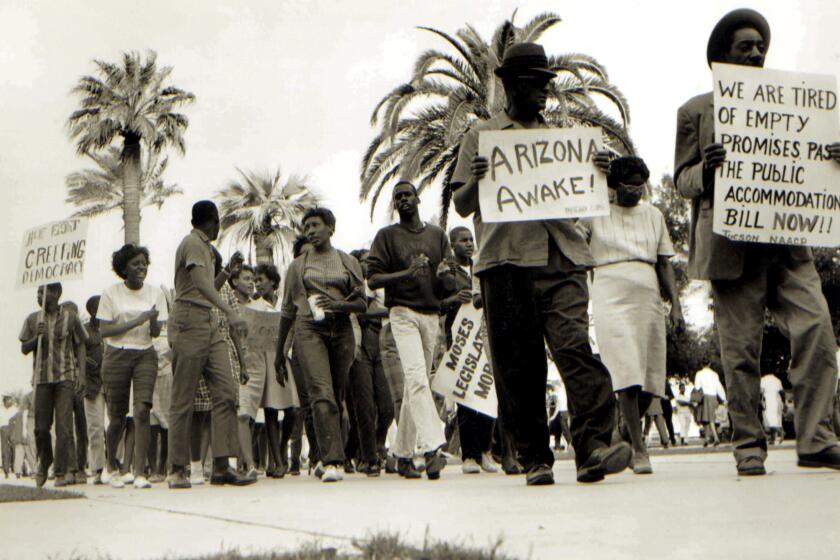In this 1962 photo, Civil Rights leader Lincoln Ragsdale and supporters march on the Arizona state capitol in Phoenix, for the desegregation of public places with the public accommodation bill prior to the Civil Rights Act of 1964. Phoenix’s past segregation has been in focus after last month’s national outrage over a videotaped encounter of police pointing guns and cursing at a black family. (Lincoln Ragsdale Jr/Matthew Whitaker Photographs, University Archives, Arizona State University Library via AP)