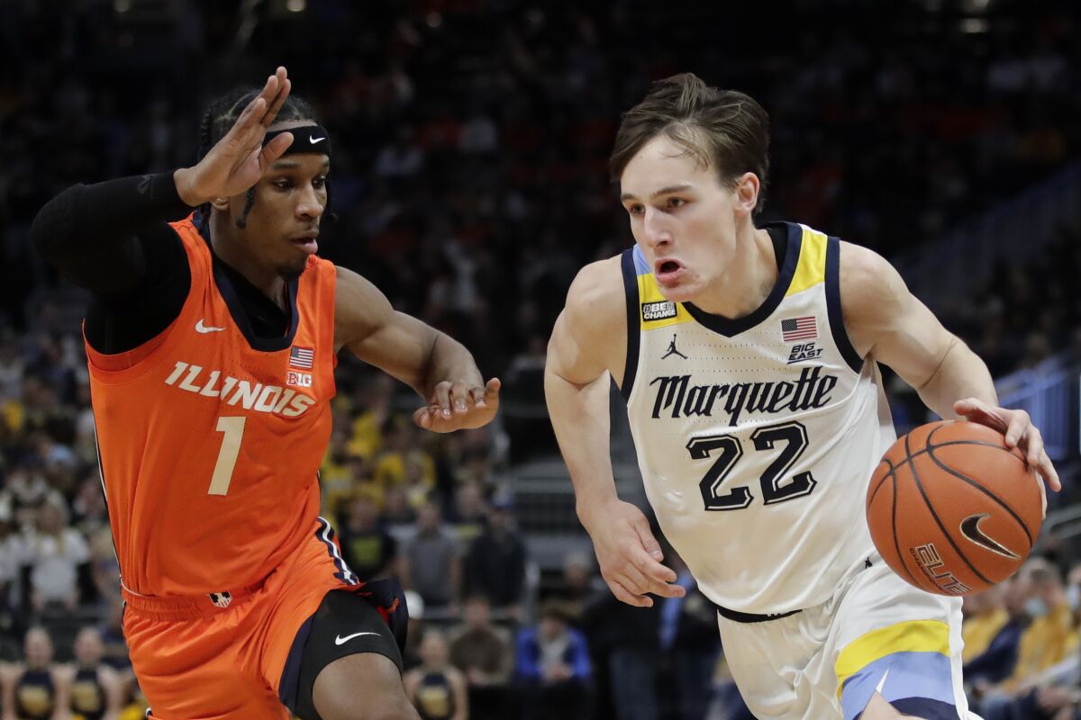 Marquette's Tyler Kolek (22) drives to the basket against Illinois' Trent Frazier (1) during the first half of an NCAA college basketball game Monday, Nov. 15, 2021, in Milwaukee. (AP Photo/Aaron Gash)