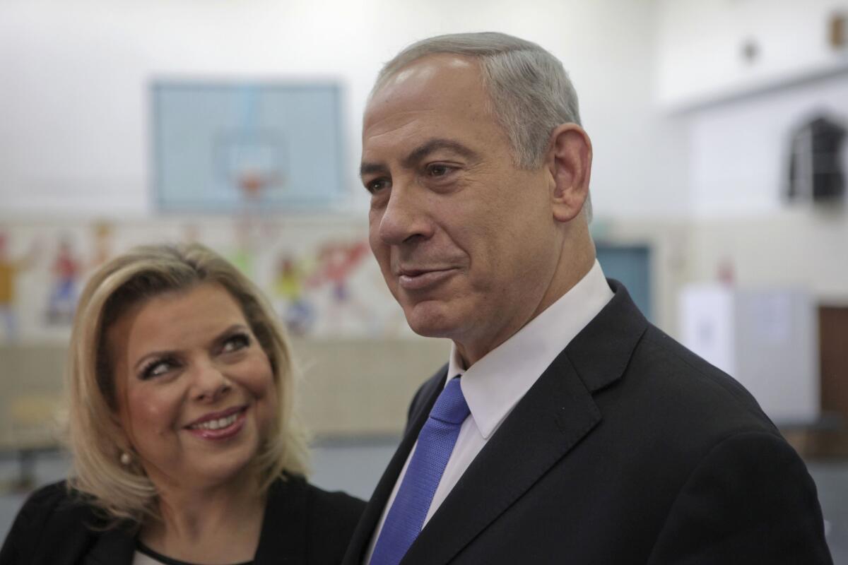In this 2013 file photo, Israeli Prime Minister Benjamin Netanyahu stands with his wife Sara, after voting in the municipal elections in Jerusalem.