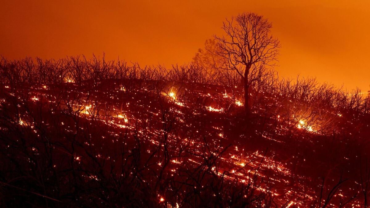 Embers smolder on a hillside in the Mendocino Complex fire on Sunday.