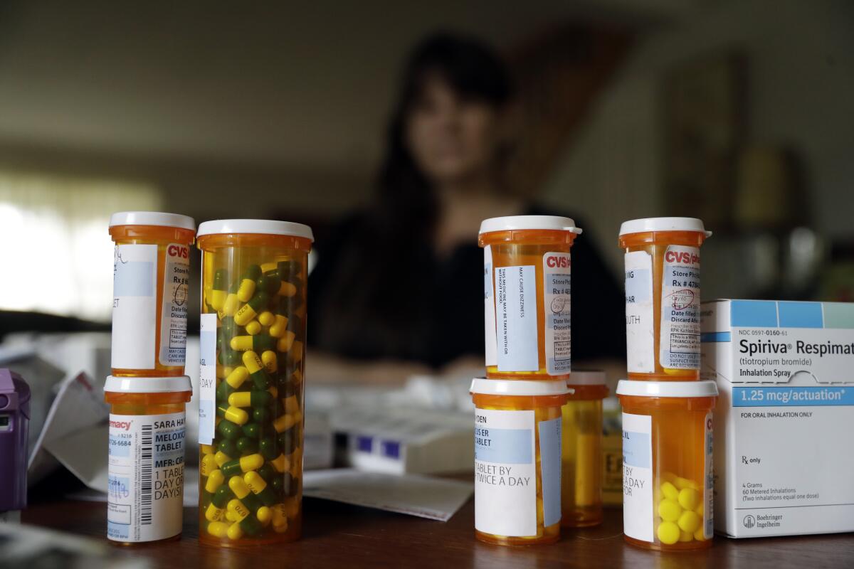 A woman with some of her medications at home in Half Moon Bay.