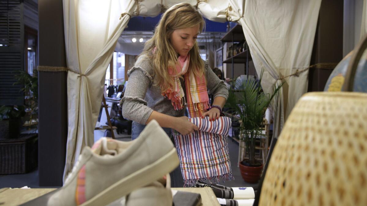 A worker at an American Rhino apparel store folds items this week in Boston. Despite low unemployment, a survey by USC and the Center for Financial Services Innovation found a minority of Americans have their financial house in order, while most are still struggling financially.