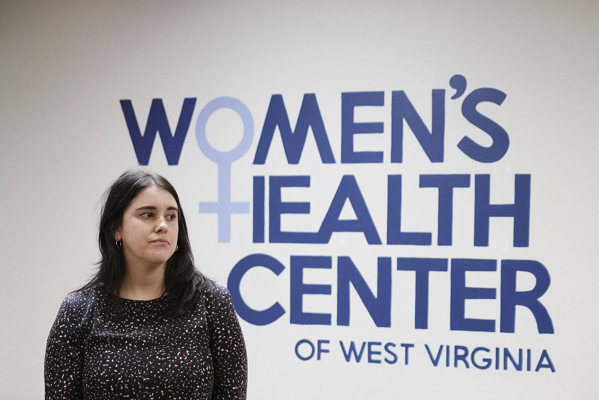 Katie Quiñonez in front of a Women's Health Center of West Virginia sign.