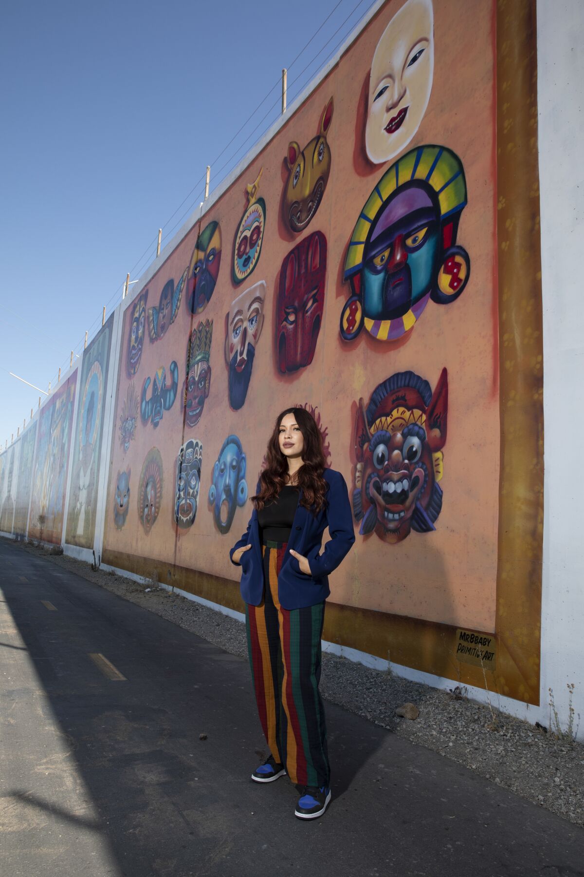 Michelle Ruby Guerrero, also known as Mrbbaby, stands in front of one of her favorite murals she painted  in Chula Vista.
