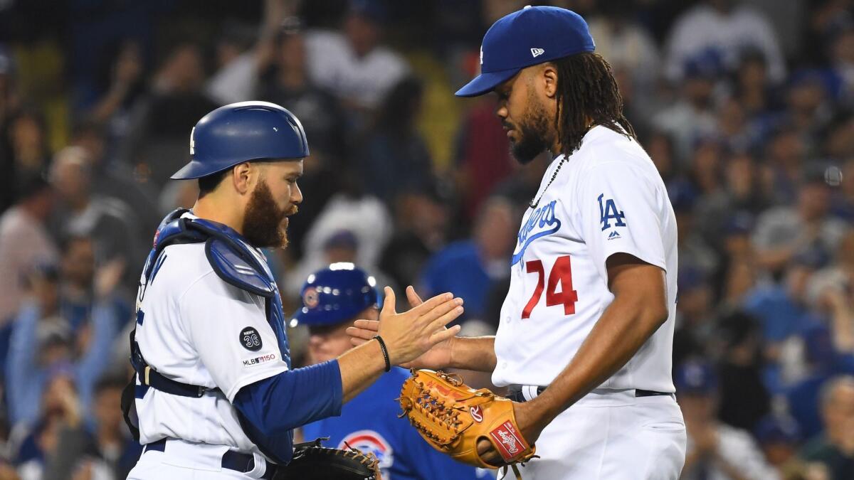 Dodgers pitcher Kenley Jansen, right, shakes hands with catcher Russell Martin after earning a save against the Chicago Cubs at Dodger Stadium on Friday.