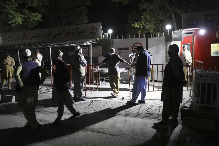 Afghans wait outside the hospital to see their relatives in Kabul, Afghanistan, Friday, April 30, 2021. A powerful suicide truck bombing struck a guest house in eastern Afghanistan on Friday, killing at least 14 people and wounding as many as 90, the Interior Ministry said. (AP Photo/Rahmat Gul)