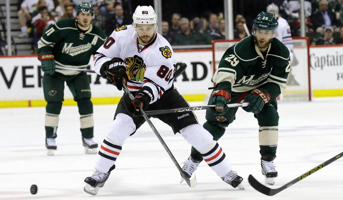 Chicago Blackhawks center Antoine Vermette and Minnesota Wild right wing Jason Pominville chase for the puck during the second period of Game 3 in the second round of the Stanley Cup hockey playoffs on Tuesday.
