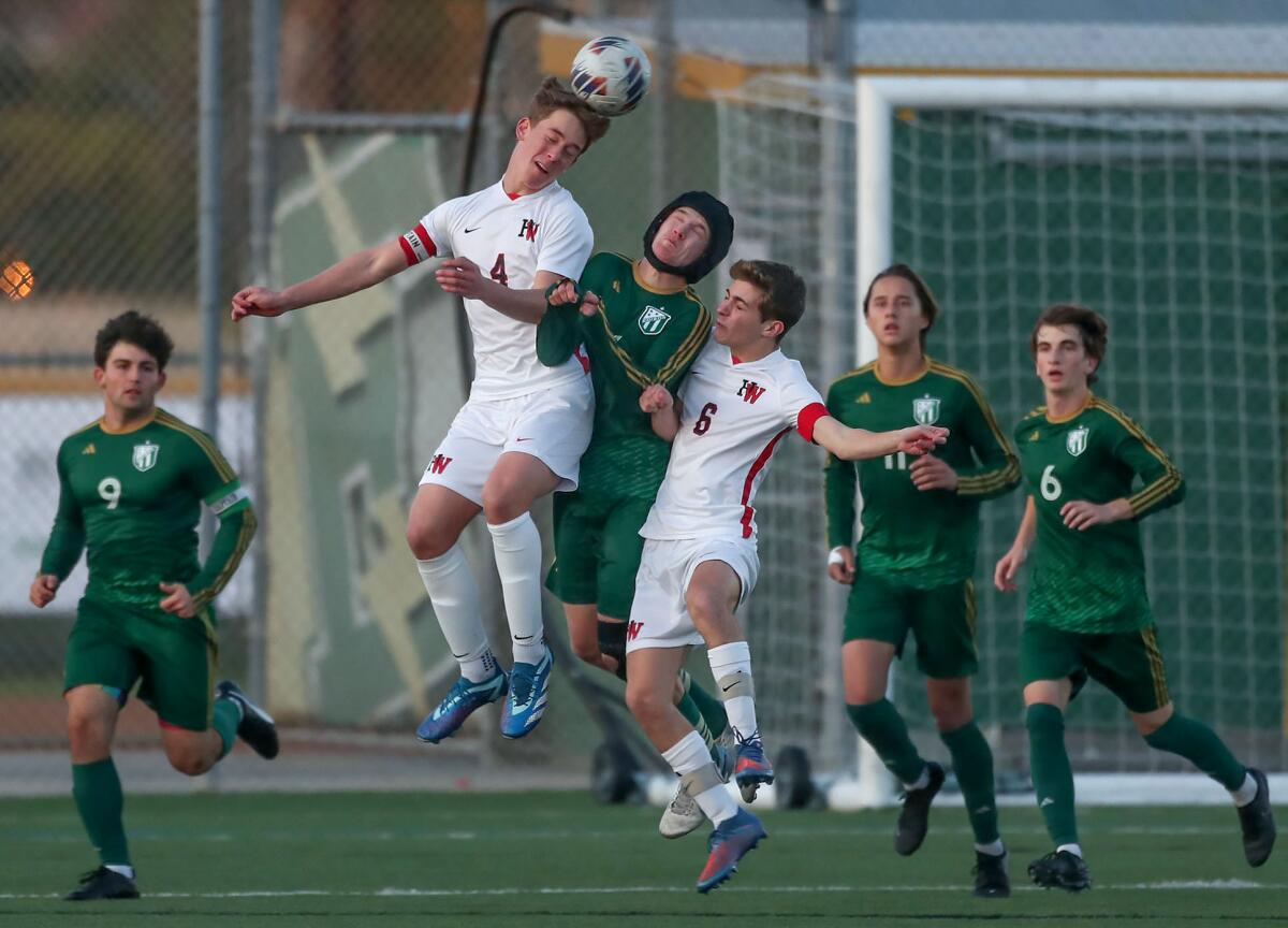 Edison's Nathan Jackson battles between Harvard-Westlake's James Federman (4) and Nathan Casamassima (6) for ball control .