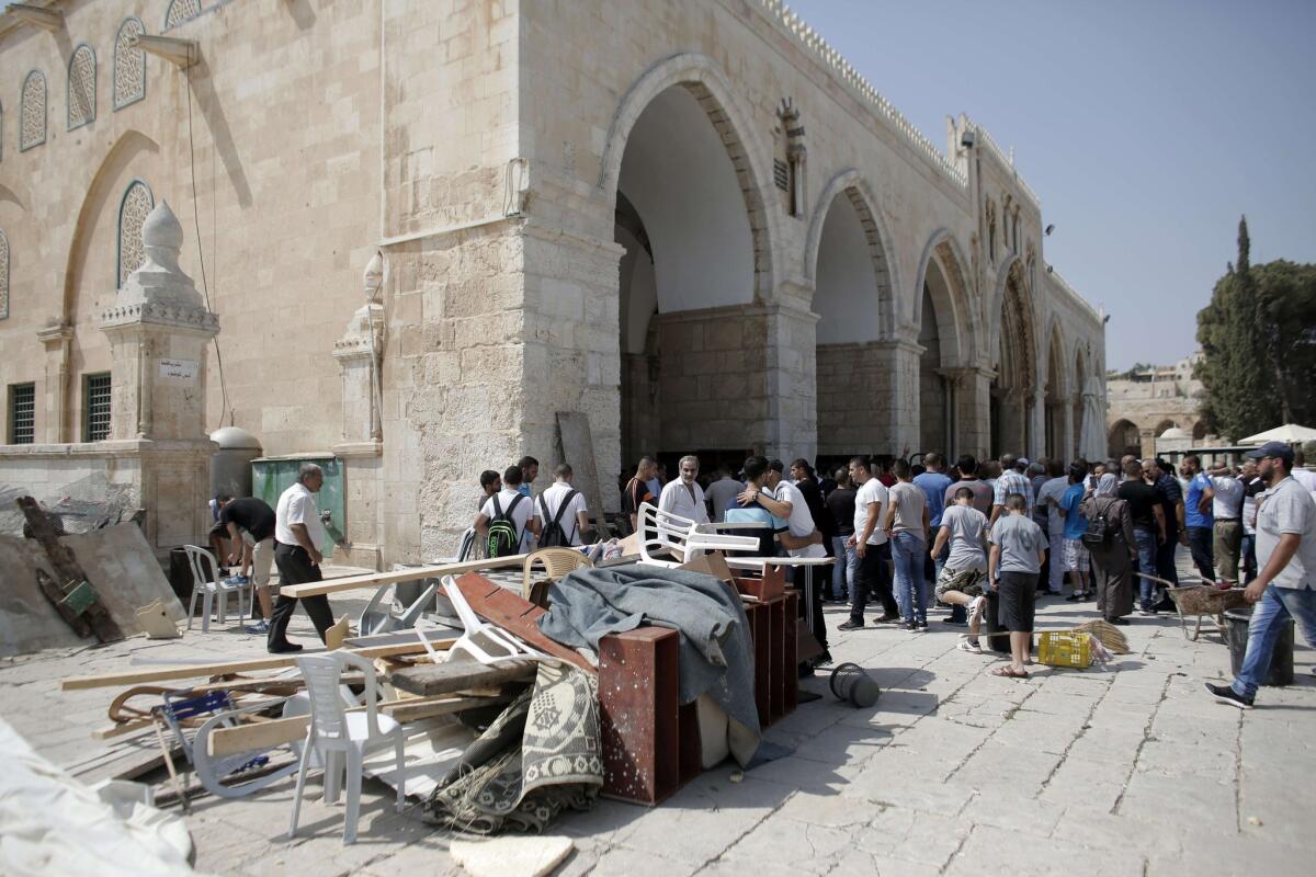 Palestinians gather Sept. 15 to inspect the damage at the entrance of Al Aqsa mosque in Jerusalem's Old City after clashes with Israeli riot police.