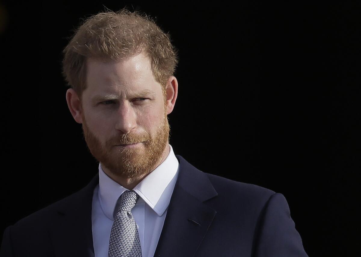 Prince Harry in a dark suit with a tie