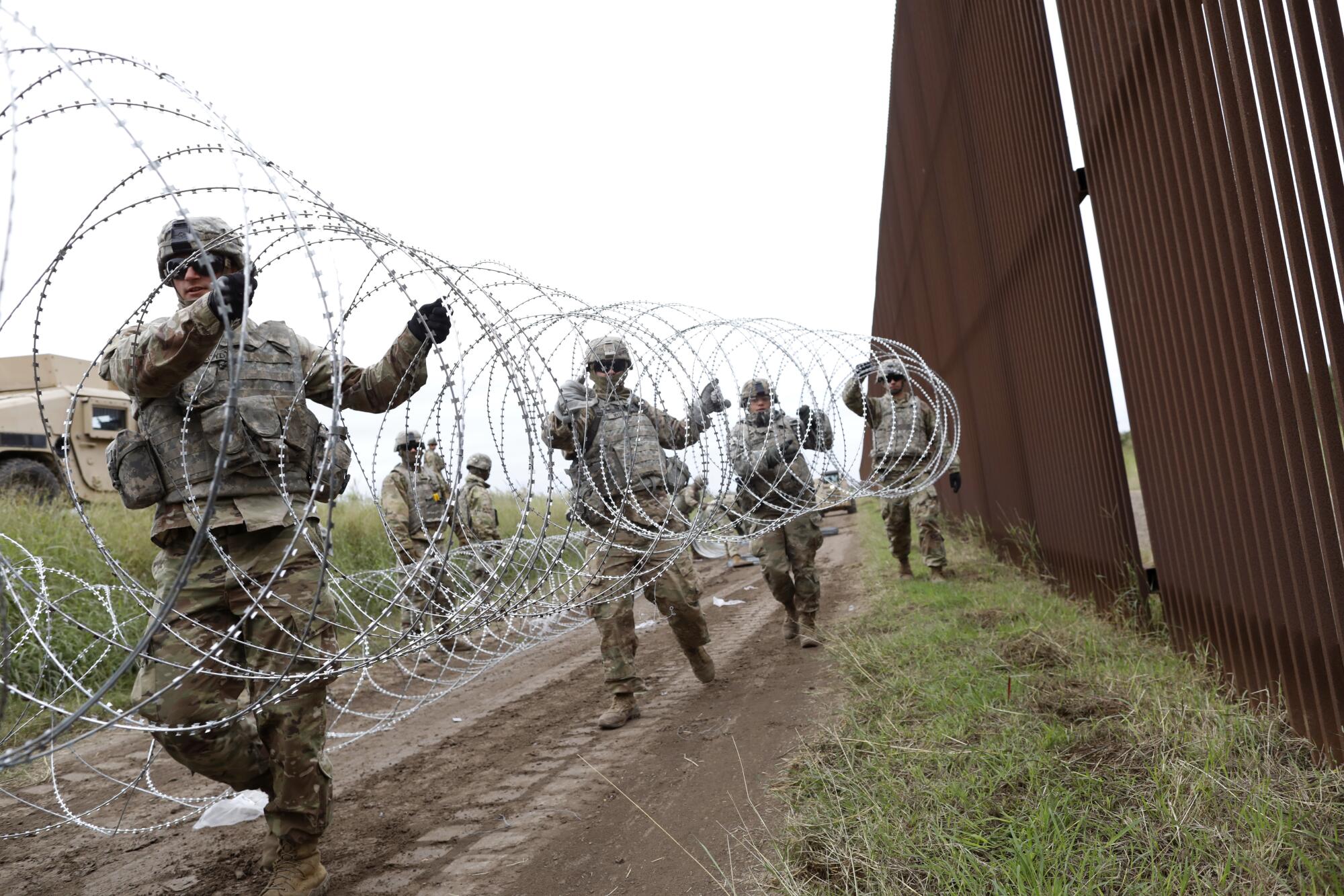 Soldiers install wire.