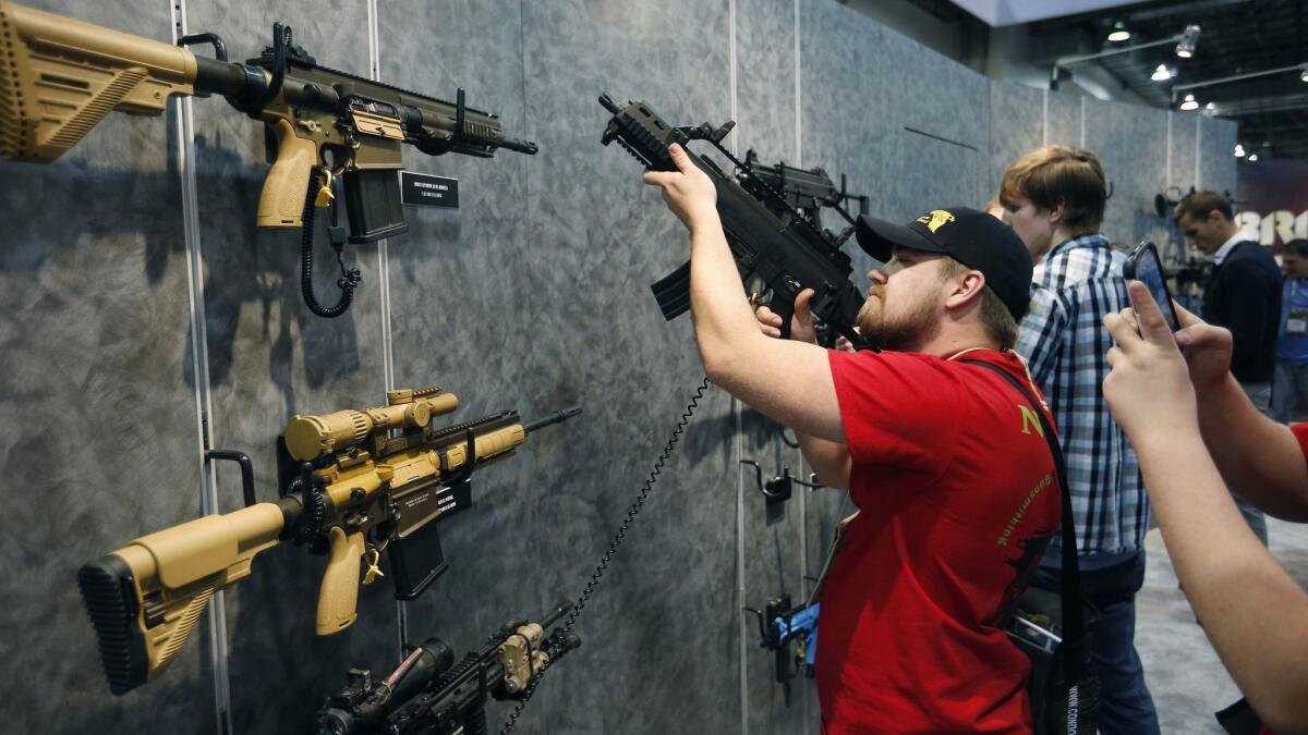 A man looks at a gun during a shooting, hunting and outdoor trade show in Nevada in 2016. The OC Fair & Event Center in Costa Mesa is scheduled to host the Crossroads of the West Gun Show on Saturday and Sunday.