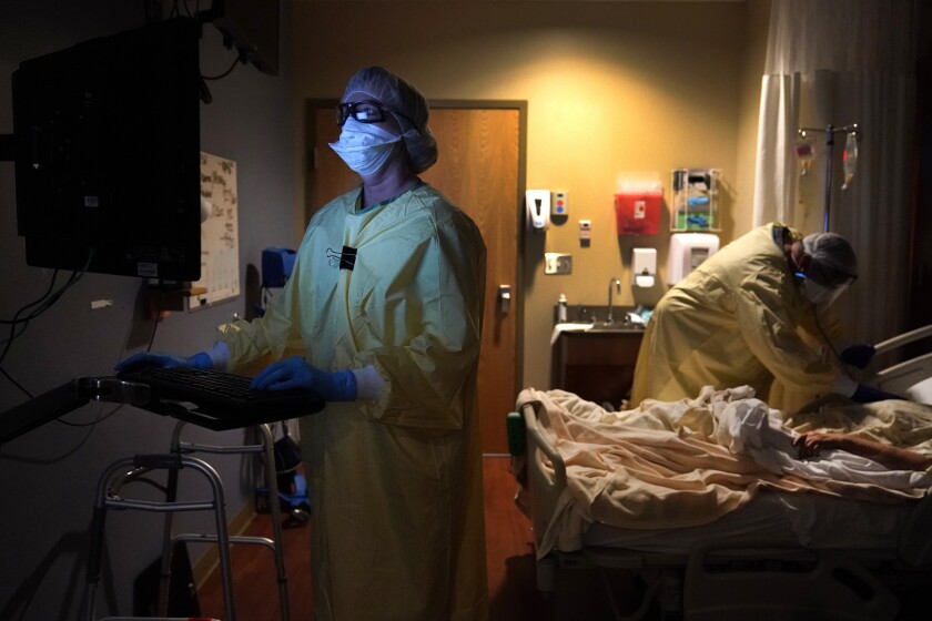 La enfermera Shelly Girardin y el doctor Shane Wilson (al fondo) examinan a Neva Azinger