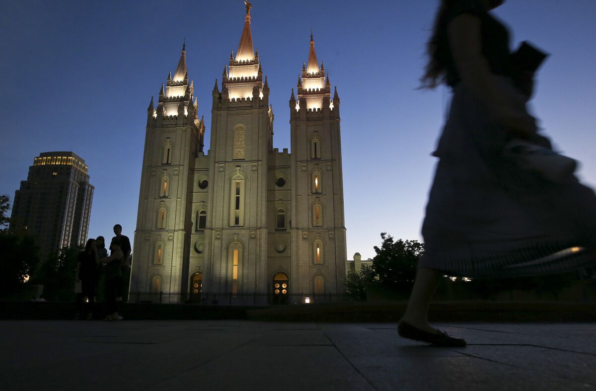 An LDS missionary passes by the Salt Lake Temple at Temple Square in Salt Lake City. Voters this fall in Utah will cast ballots on a measure that would allow medical marijuana.