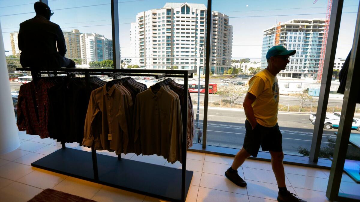 Dan Mock of Serra Mesa walks past large picture windows in the men's department at the new Nordstrom store. They're meant to let in natural light for employee satisfaction and better rendition of colors for the customers.