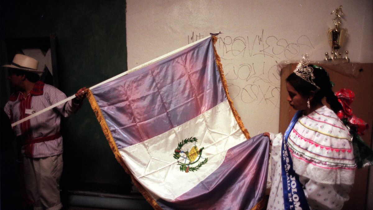 Ana Lopez looks at the Guatemalan flag before participating in a Maya ceremony in 1998 in Santa Eulalia in Guatemala. The festival was attended by Kanjobal indigenous people.
