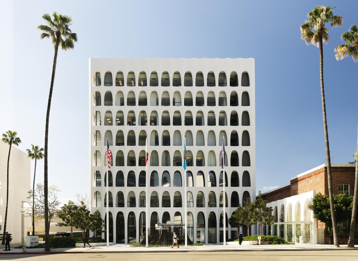 An office tower fronting a small plaza is composed of eight rows of bright Modern symmetrial arches.