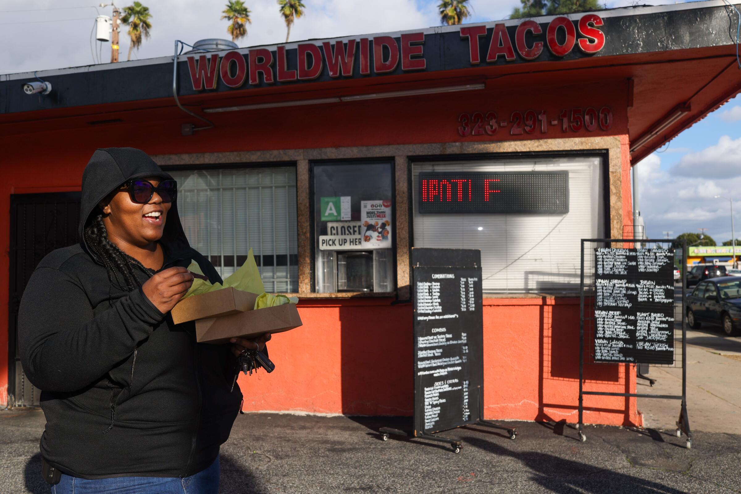 Jennifer Brown grins after receiving her tacos and burrito at Worldwide Tacos.