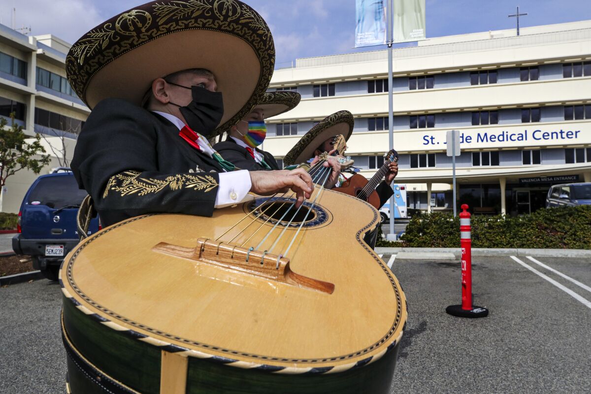 A mariachi band plays a song in a parking lot.