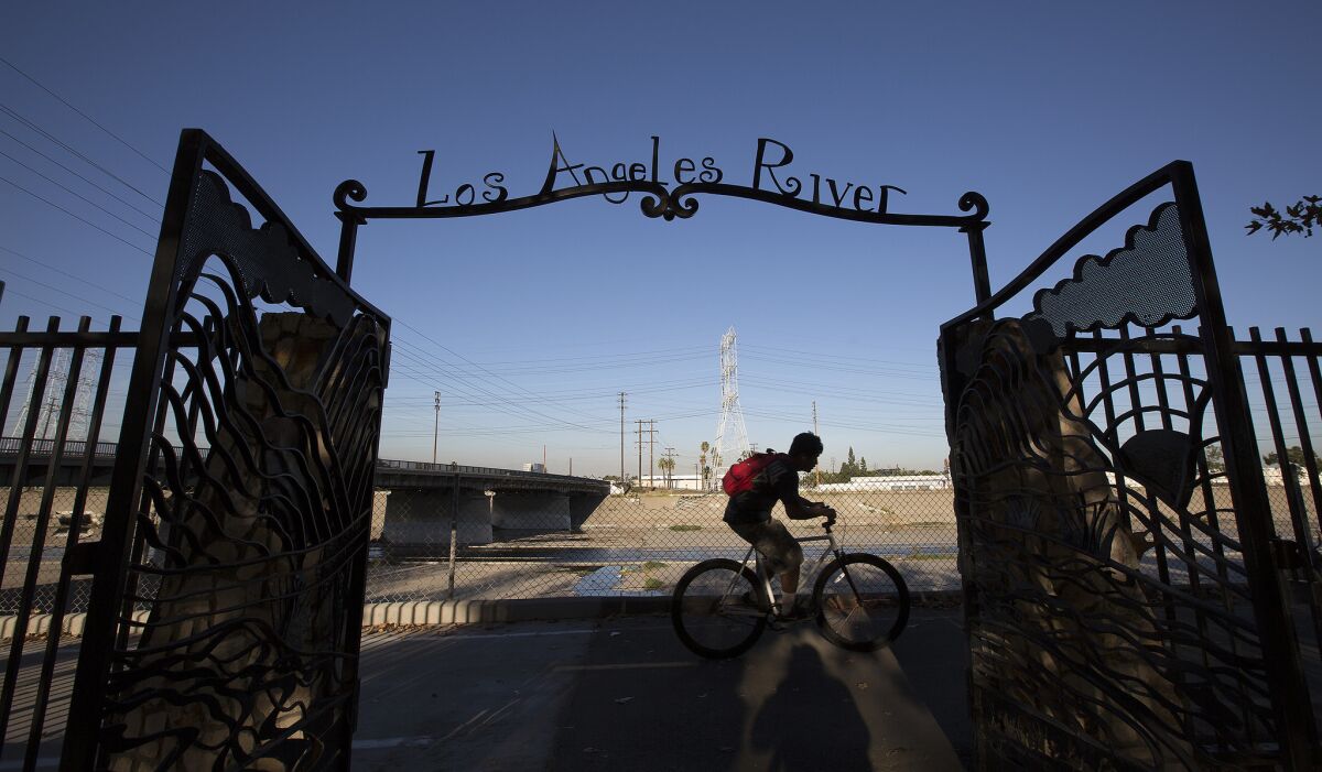 A man rides a bike along the Los Angeles River in Maywood.