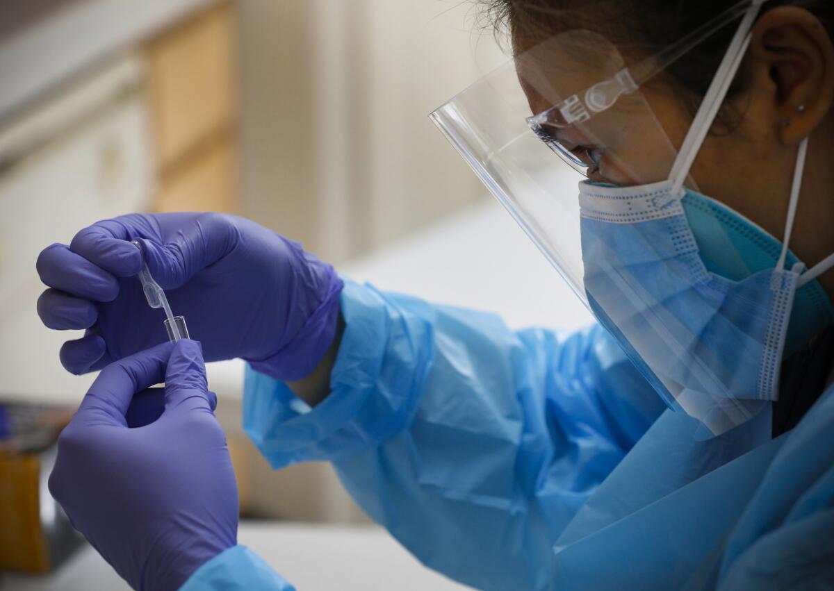 Marie Manipud, trabajadora sanitaria de la SDSU, prepara una muestra para el procesamiento 