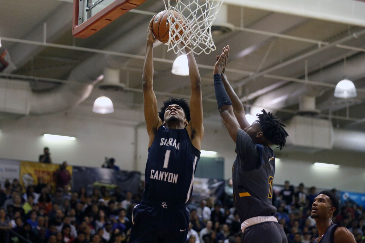 Sierra Canyon forward Ziaire Williams dunks the ball in front of Rancho Christian guard Dominick Harris during the Elite Invitational Basketball Tournament at Pasadena Community College. 