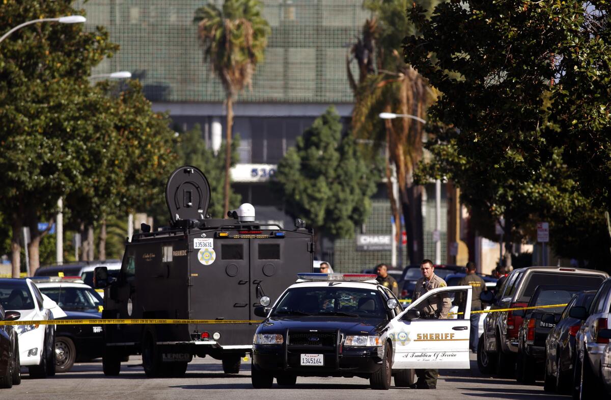 Sheriff's deputies monitor the scene where two suspects are dead following a deputy-involved shooting at Hillview Avenue and Verona Street in East Los Angeles.