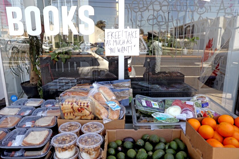 LOS ANGELES, CA - APRIL 13: Donated items on the free food table at All Power Books in the West Adams neighborhood on Wednesday, April 13, 2022 in Los Angeles, CA. All Power Books is in danger of being kicked out of its building by the landlord to allow for remodeling and renovations. This bookstore offers community services like food, clothing and school supply distributions, organizes community clinics, hosts tenants' rights workshops, etc. It's volunteer-run by self-described communists. (Gary Coronado / Los Angeles Times)