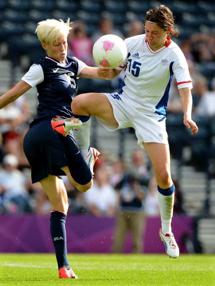 United States defender Megan Rapinoe, left, battles Elise Bussaglia of France for the ball in a preliminary round of the 2012 London Olympics in Glasgow, Scotland.