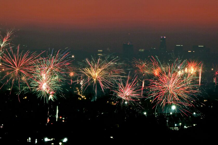 Downtown Los Angeles can be seen in the background through haze and smoke with Fourth of July fireworks going off in various neighborhoods, as seen from Whittier looking west on this 21-second single exposure on Monday, July 4, 2022.