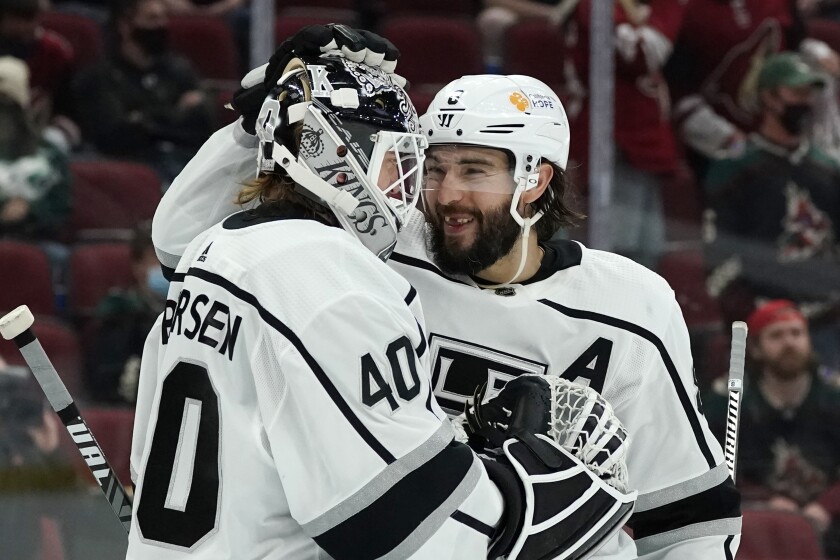 Los Angeles Kings goaltender Calvin Petersen (40) and defenseman Drew Doughty, right, congratulate each other at the end of the team's NHL hockey game against the Arizona Coyotes on Wednesday, May 5, 2021, in Glendale, Ariz. The Kings won 4-2. (AP Photo/Ross D. Franklin)