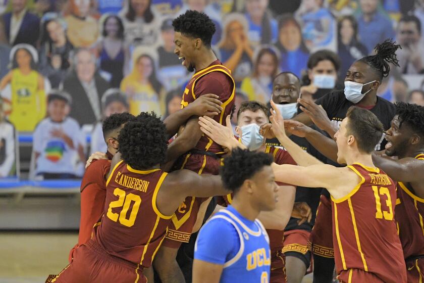 Southern California guard Tahj Eaddy, top, celebrates with teammates as UCLA guard Jaime Jaquez Jr.