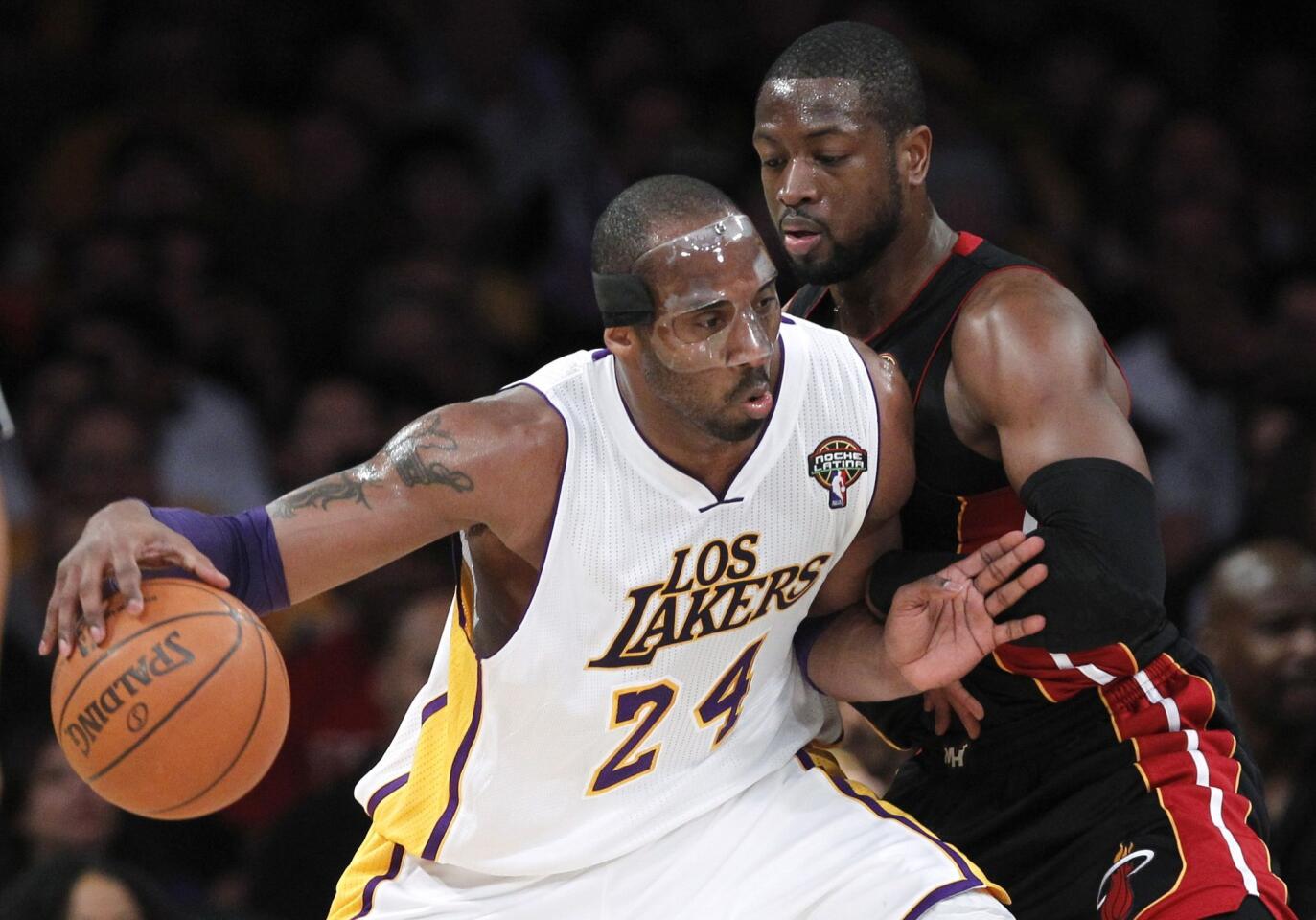 Los Angeles Lakers' Bryant drives on Miami Heat's Wade during the first half of their NBA basketball game in Los Angeles