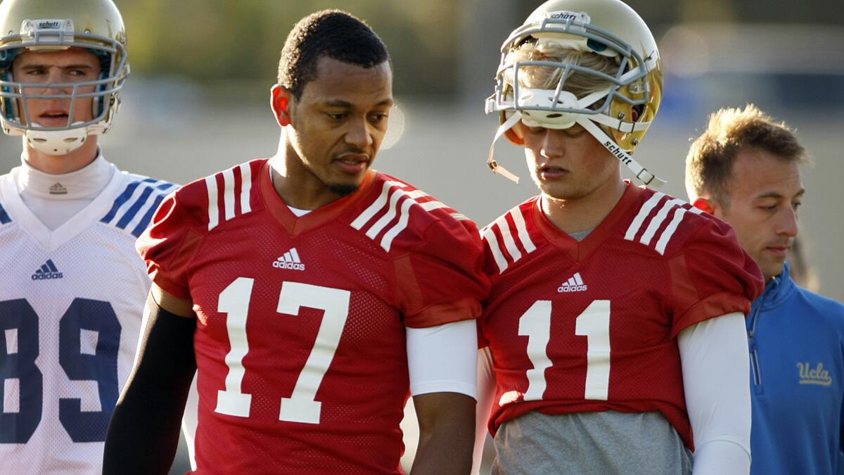 UCLA quarterbacks Brett Hundley, left, and Jerry Neuheisel speak to one another during a morning practice session in April. Expectations are high for UCLA as it prepares to embark on the 2014 season.