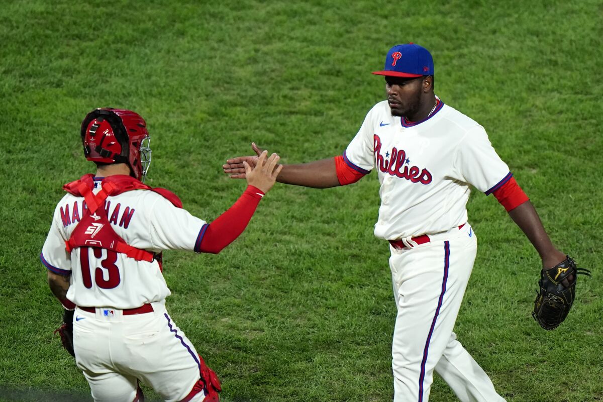 Philadelphia Phillies pitcher Hector Neris, right, and catcher Rafael Marchan celebrate after winning the second baseball game in a doubleheader against the Toronto Blue Jays, Friday, Sept. 18, 2020, in Philadelphia. (AP Photo/Matt Slocum)