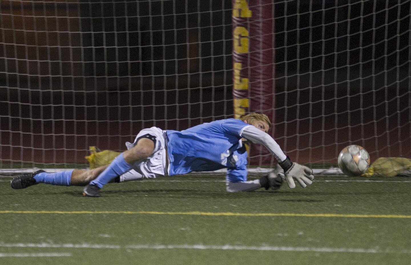 Corona del Mar's Gavin Allen dives for a save on goal during a game against Estancia on Wednesday, December 17.
