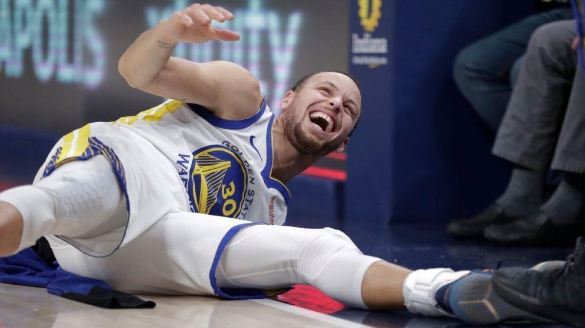 Golden State Warriors guard Stephen Curry is floored by a dunk by guard Klay Thompson during the first half of an NBA game against the Indiana Pacers in Indianapolis on Jan. 28, 2019.