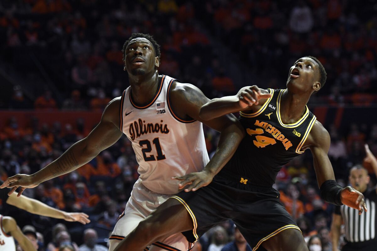 Illinois' Kofi Cockburn (21) and Michigan's Moussa Diabate vie for a rebound during the first half of an NCAA college basketball game Friday, Jan. 14, 2022, in Champaign, Ill. (AP Photo/Michael Allio)