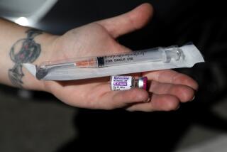 SANTA ANA, CA - FEBRUARY 10: Emily Pomerantz (cq), peer suuport case manager, of Harm Reduction Institute, shows a single dose of naloxone and a syringe used for naloxone kits to hand out to clients who use opioids on Thursday, Feb. 10, 2022 in Santa Ana, CA. Workers at the Harm Reduction Institute, which shut down its offices in Santa Ana after the city revoked its occupancy permit, hand out naloxone - a medicine that can reverse an opioid overdose - on the streets. The workers now have to operate out of a storage facility. (Gary Coronado / Los Angeles Times)