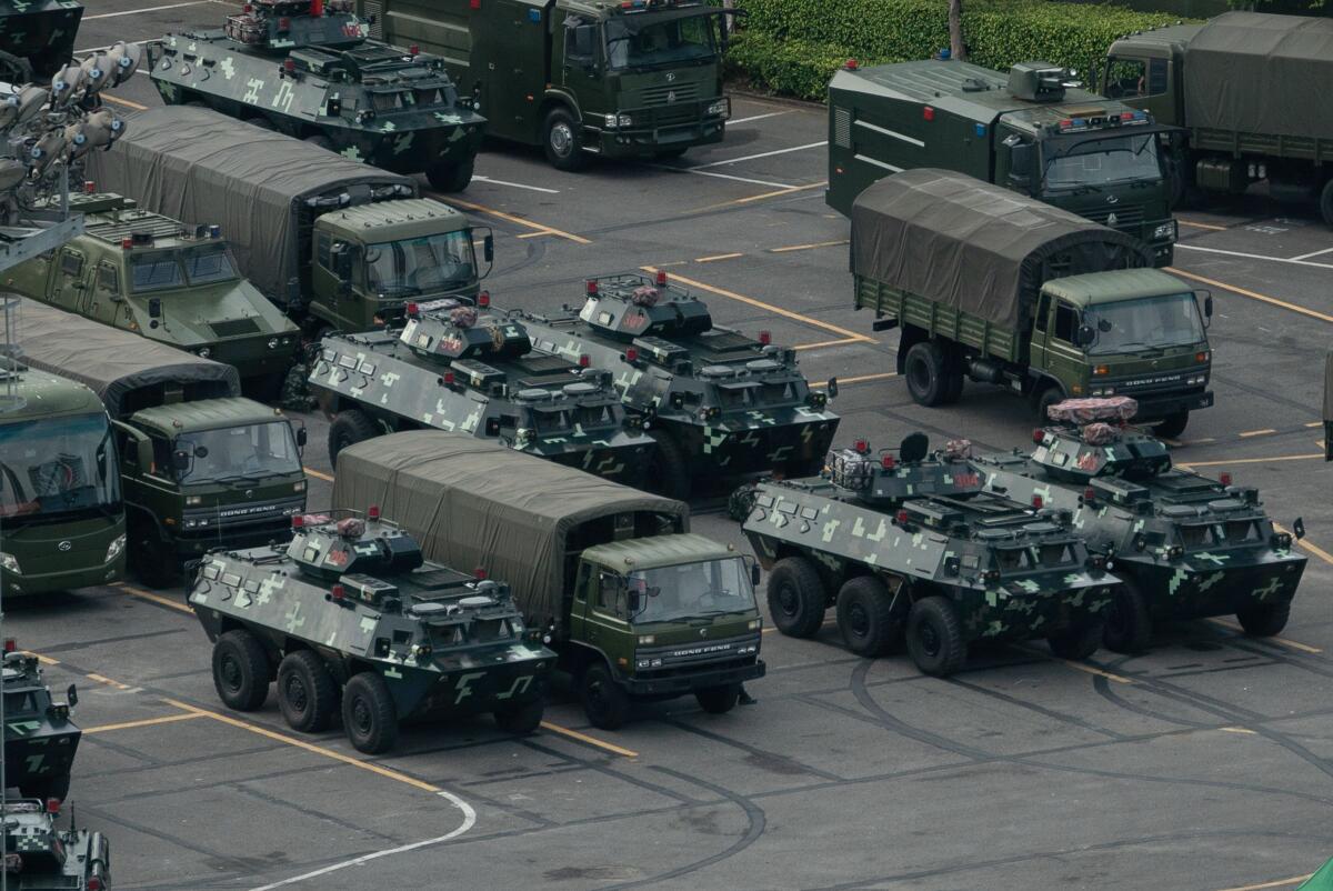 Trucks and armored personnel carriers are seen parked at the Shenzhen Bay stadium in Shenzhen, bordering Hong Kong in China's southern Guangdong province.