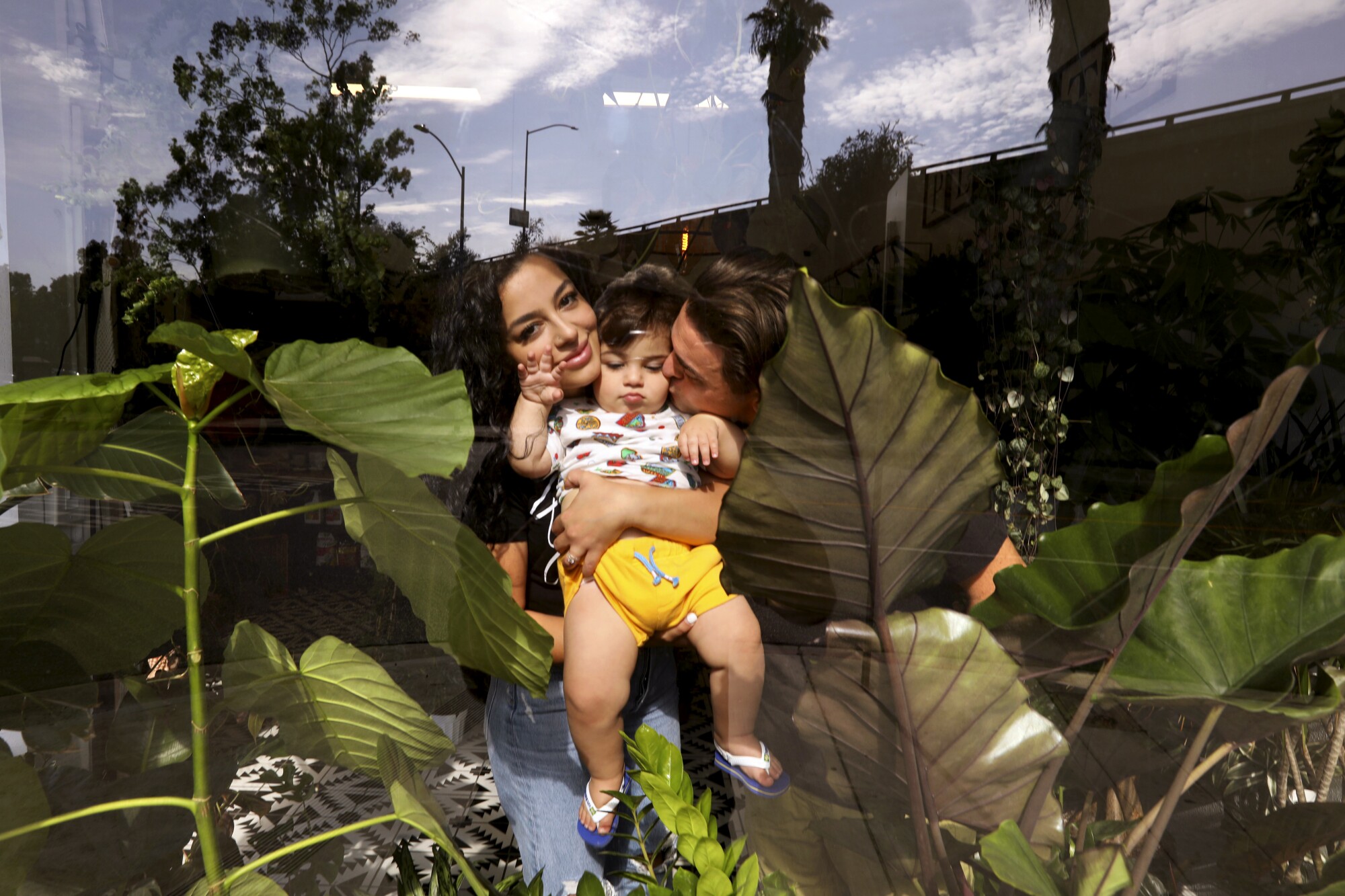 Parents hold their young child among plants