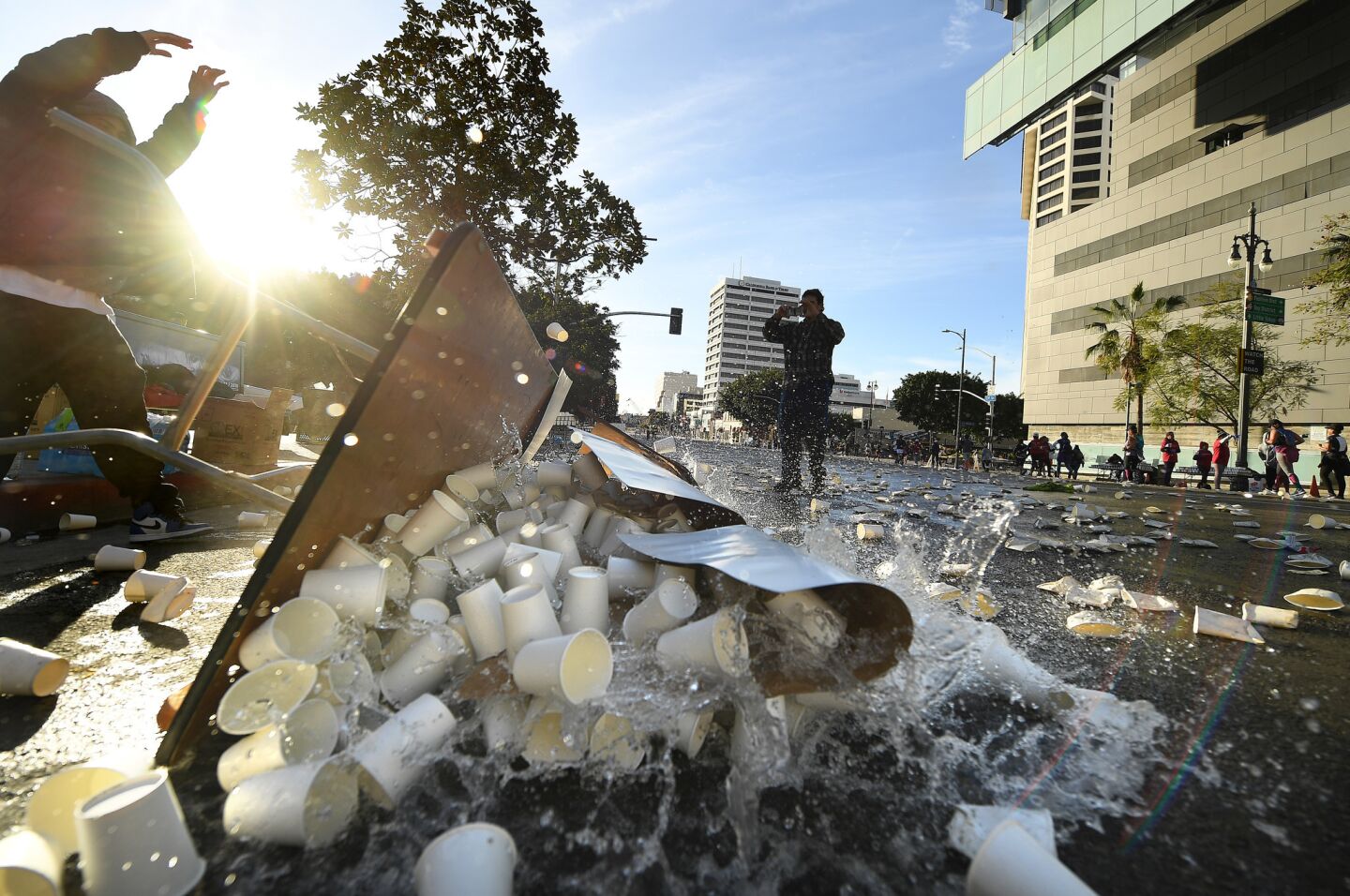 Water is dumped after the last runners pass by during the L.A. Marathon.