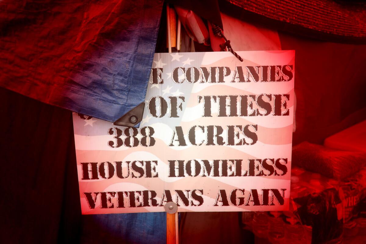 A sign in support of housing for homeless veterans sits outside a tent on Veterans Row 