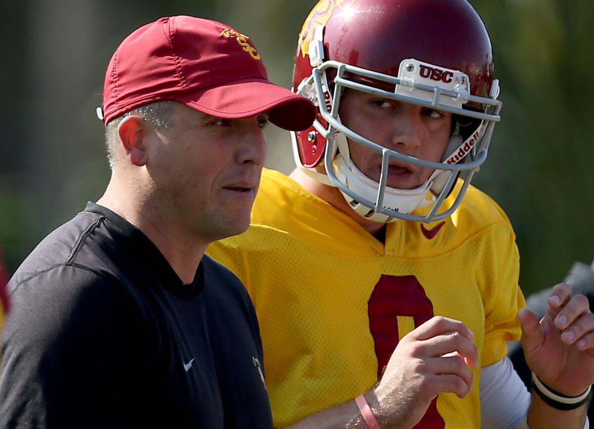 Clay Helton works with Trojans quarterback Cody Kessler during a practice on Oct. 2, 2013.