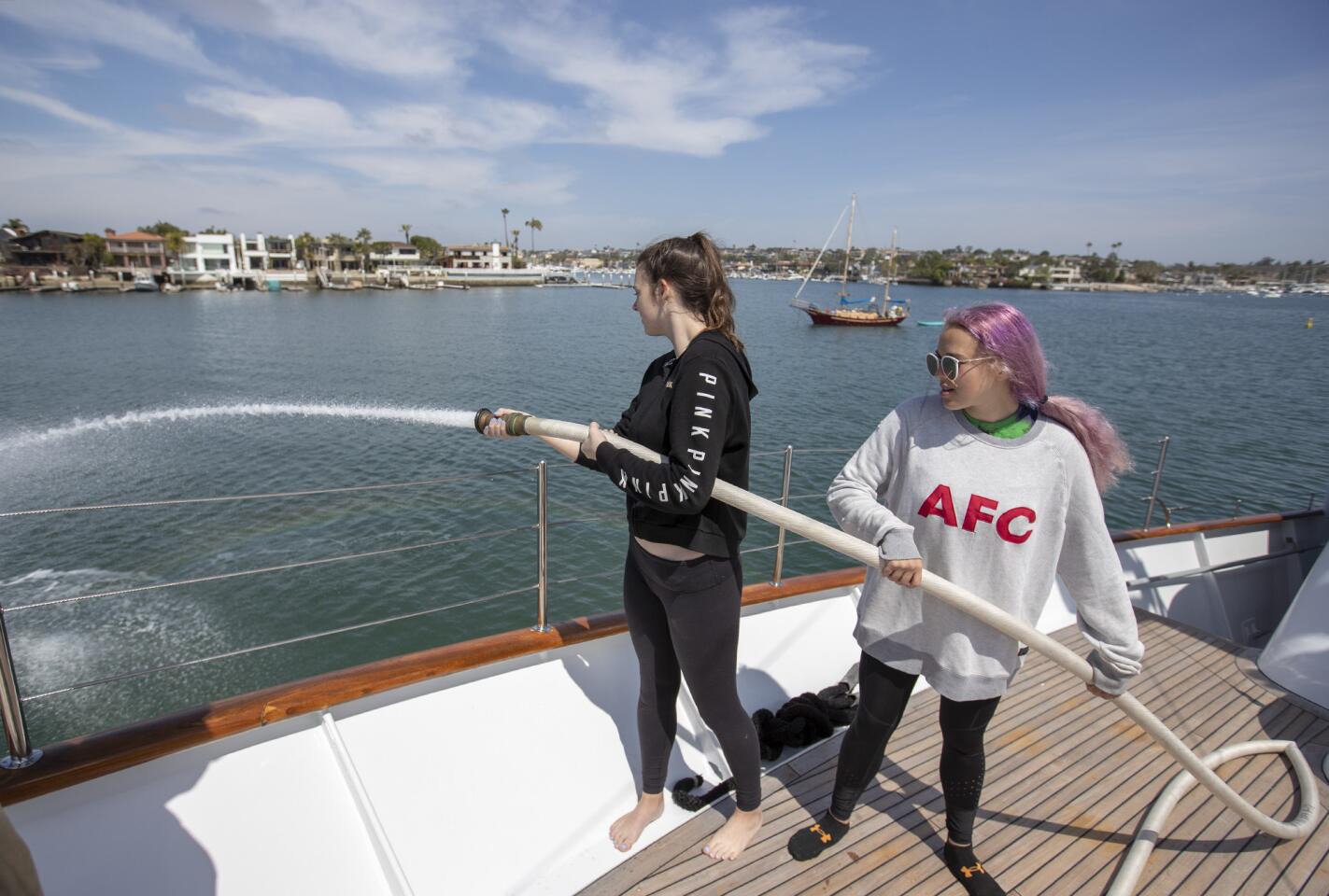 Daniella Daboub, 17, left, and Meredith McCuskey, 18, practice using the fire hose aboard Orange Coast College's Nordic Star on April 24.