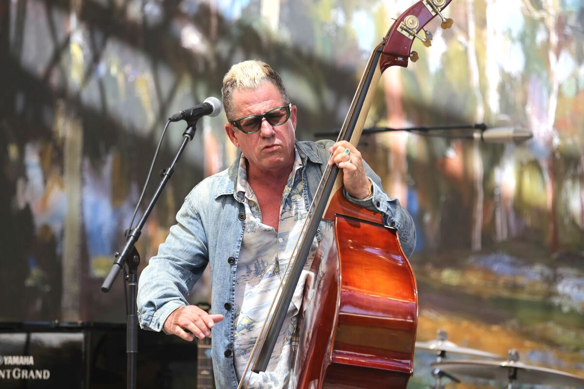 Lee Rocker of the Stray Cats plays the standup bass as he performs during the Festival of Arts 90th anniversary celebration.