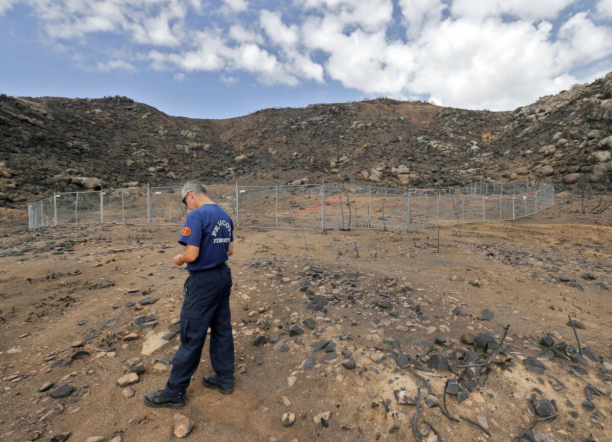Prescott, Ariz., firefighter Wade Ward stands alone in July at the fenced-in site where 19 firefighters died battling an wildfire on June 30.