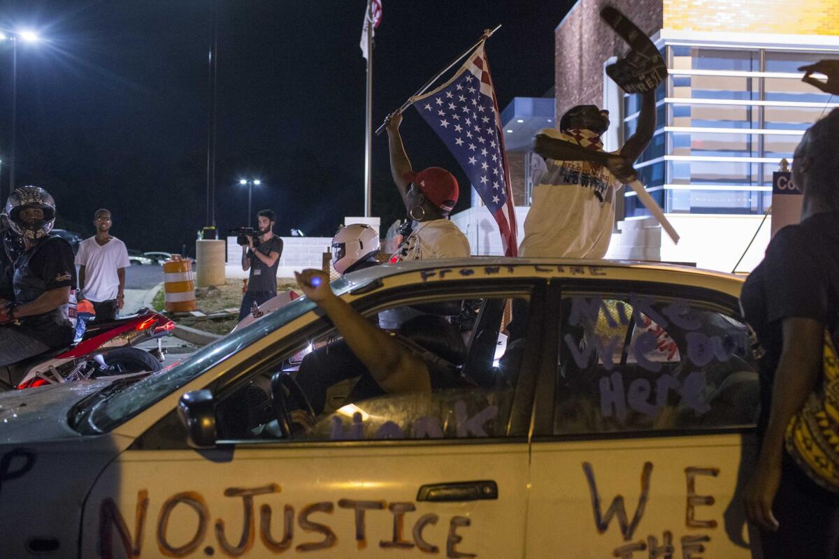 Protesters gather in front of the police station in Ferguson, Mo.